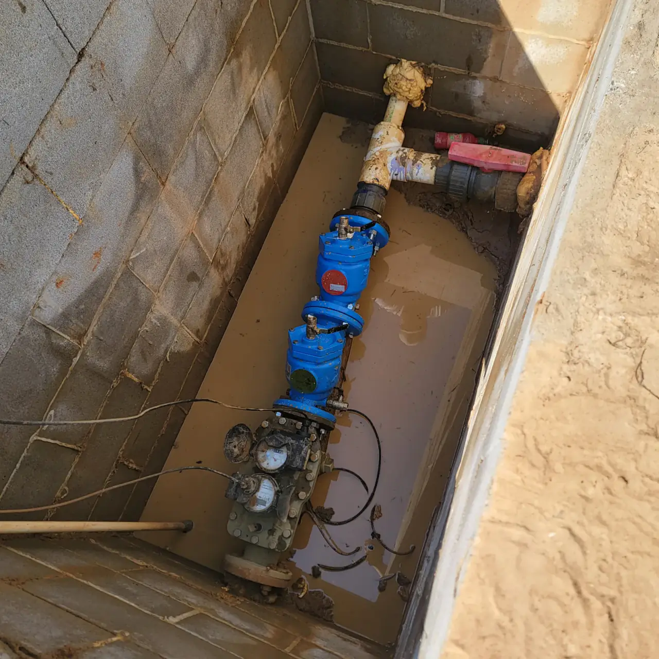 Commercial water meter vault with valves serviced by Odyssey Plumbing Co
