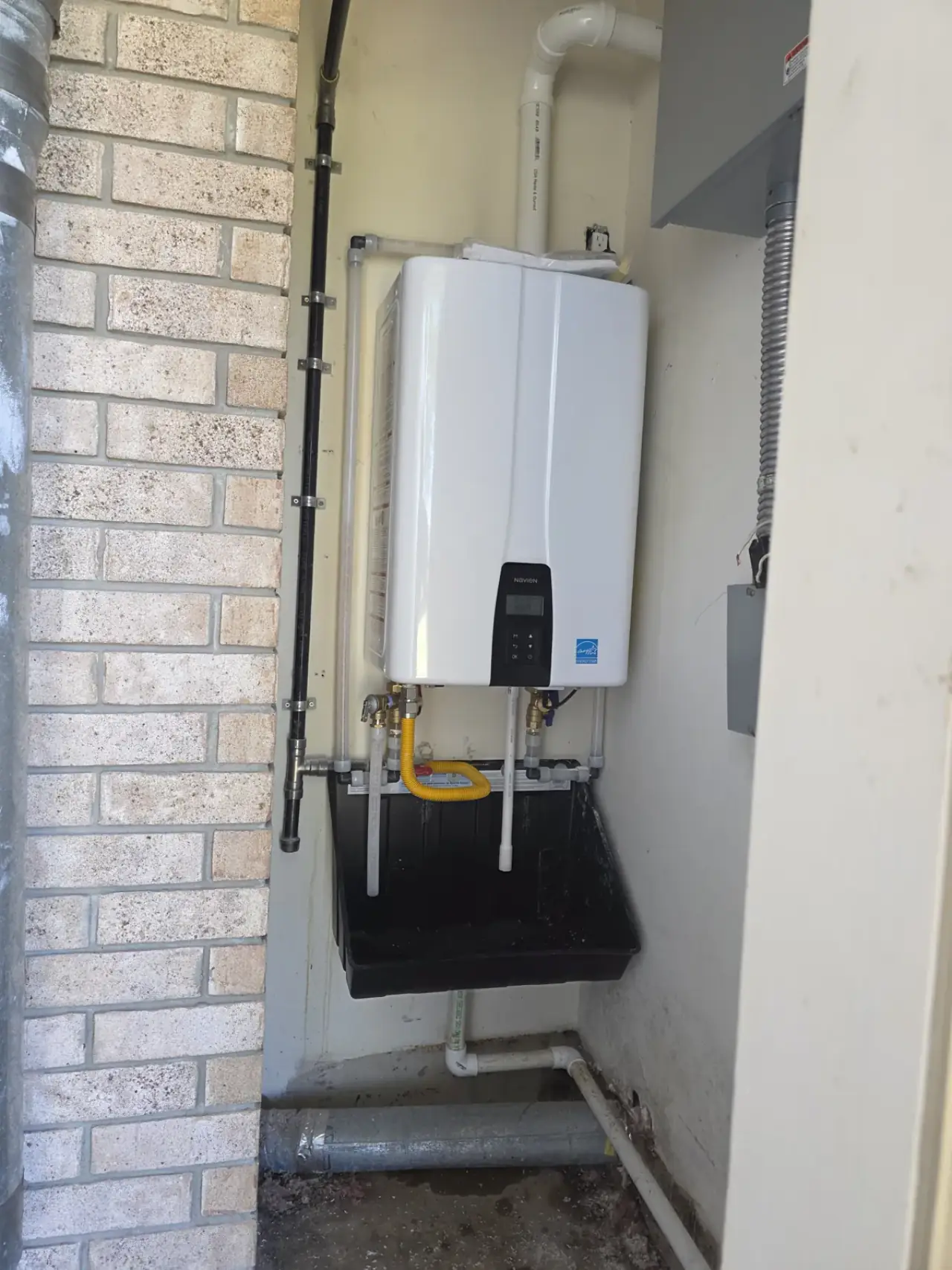 Wall-mounted tankless water heater installed by Odyssey Plumbing Co in East Texas